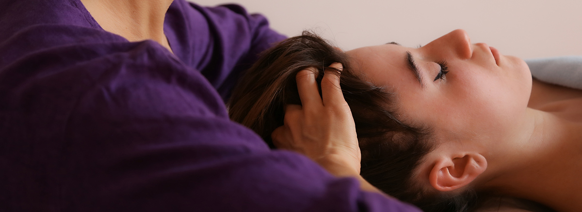Silvia Maiorana di InVita nell'atto di praticare il massaggio di psicosomatica essenziale poggiando le mani sulla testa della cliente